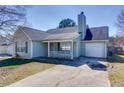 Exterior view of home, showing attached garage and front porch at 6715 Biscayne Blvd, Rex, GA 30273