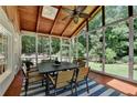 Enclosed patio features wood ceiling with skylight, ceiling fan, tile floor and screened windows at 9585 Fenbrook Ct, Johns Creek, GA 30022