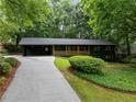 Charming single-story home with green siding, mature trees, and a covered portico at 2356 Sherbrooke Ne Dr, Atlanta, GA 30345
