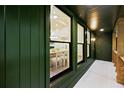 Covered patio featuring green wood siding, brick accent wall, and views to the dining room at 2356 Sherbrooke Ne Dr, Atlanta, GA 30345