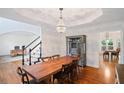Elegant dining room boasts hardwood floors, coffered ceilings, and a modern chandelier with views of the staircase at 640 Windwalk Dr, Roswell, GA 30076