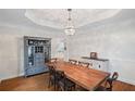 Elegant dining room boasts hardwood floors, coffered ceilings, and a modern chandelier with bar cabinet at 640 Windwalk Dr, Roswell, GA 30076
