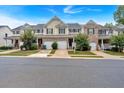 Well-maintained townhomes feature attached garages, manicured lawns, and tree-lined street for curb appeal at 442 Colonial Walk, Woodstock, GA 30189