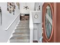Inviting foyer with staircase, featuring a modern color palette and stylish front door with oval glass at 218 Depot Ln, Dallas, GA 30157