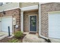 Close-up of townhome entrance with brick facade, front door and manicured landscaping at 3271 Pennington Dr, Stonecrest, GA 30038