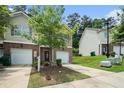 View of the townhouse with attached garage, front lawn, and easy access parking at 3271 Pennington Dr, Stonecrest, GA 30038