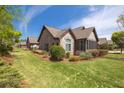 Beautiful home with manicured lawn and landscaping, a stone facade, and an enclosed sunroom at 328 Brookhaven Walk, Johns Creek, GA 30097