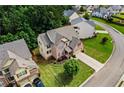 Aerial view of a charming brick home with manicured lawn and mature trees in a suburban neighborhood at 6175 Beaver Crossing Dr, Cumming, GA 30040