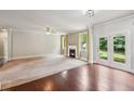 Spacious living room with hardwood floors, a cozy fireplace, and glass doors leading to the backyard at 1610 Kenilworth Se Ln, Conyers, GA 30013
