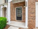 Inviting front entrance with a black door, brick facade, white accents, and manicured greenery at 2776 Snapfinger Mnr # 2776, Decatur, GA 30035
