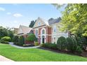 Lovely traditional-style home featuring a lush green lawn and mature trees for privacy and shade at 3741 Cape York Trce, Alpharetta, GA 30022