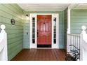 A charming red front door is surrounded by white trim and sidelights at 1920 Daves Creek Trl, Cumming, GA 30041