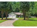 Inviting single-story home with lush lawn, mature trees, and a two-car garage at 1920 Daves Creek Trl, Cumming, GA 30041