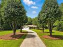 Traditional one-story home with manicured lawn, long driveway, and mature shade trees at 1920 Daves Creek Trl, Cumming, GA 30041