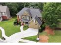 Aerial view of a beautiful home with a large driveway, manicured lawn and mature trees at 28 Mcevers Branch Ct, Acworth, GA 30101