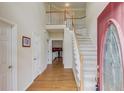 Inviting foyer with hardwood floors, staircase, and views into the adjoining rooms at 3082 Biltmore Woods Dr, Buford, GA 30519