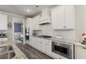 Modern kitchen featuring stainless steel appliances, granite countertops, and stylish white cabinetry at 3392 Fall Branch Ln, Buford, GA 30519
