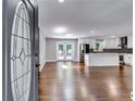 Open-concept living room with wood floors, white walls and trim, and an adjacent modern kitchen at 3122 Vandiver Dr, Marietta, GA 30066