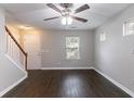 View of the living room with hardwood floors, a ceiling fan, and a staircase at 3458 Carriage Chase Rd, Atlanta, GA 30349
