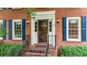 Close-up of a red brick home's front entrance with black shutters and a storm door at 4313 Deep Springs Nw Ct, Kennesaw, GA 30144