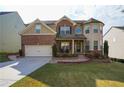 Charming two-story home with a brick facade, manicured lawn, and attached two-car garage at 3770 Falling Leaf Ln, Cumming, GA 30041