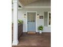 Inviting front porch featuring a stylish blue door, classic lighting, and a 'Welcome' mat on a wooden deck at 55 Cooper Lake Rd, Mableton, GA 30126