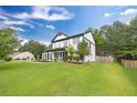Well-maintained two-story home featuring a lush green lawn, and charming front porch at 8320 Mayfern Dr, Fairburn, GA 30213