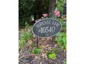 Serenbe Lane address sign with blooming pink roses in landscaped flower bed at 10540 Serenbe Ln, Chattahoochee Hills, GA 30268
