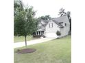 Well-maintained two-story home with a two-car garage, landscaped yard, and mature trees at 124 Gorham Gates Ct, Hiram, GA 30141