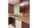 Kitchen with stainless steel sink, window, and dark wood cabinets at 1807 Ashborough Se Cir # B, Marietta, GA 30067