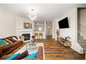Bright living room featuring hardwood floors, fireplace, modern lighting, and neutral wall paint at 920 Society Sw Cir, Atlanta, GA 30331