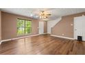 Bright living room featuring hardwood floors, a ceiling fan, and natural light from a large window at 1382 Hollenbeck Ln, Riverdale, GA 30296