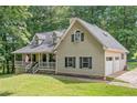Charming home with a welcoming front porch, a neatly kept lawn and an attached two car garage at 1580 Lower Burris Rd, Canton, GA 30114