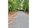 Gravel driveway leading to a cozy log cabin nestled among the trees at 5642 Dorsett Shoals Rd, Douglasville, GA 30135