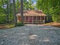 Log cabin with a quaint front porch nestled among mature trees at 5642 Dorsett Shoals Rd, Douglasville, GA 30135