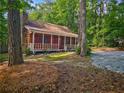 Charming log cabin with a stone chimney and inviting front porch at 5642 Dorsett Shoals Rd, Douglasville, GA 30135