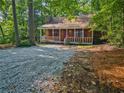 Cozy log cabin with front porch, surrounded by lush greenery at 5642 Dorsett Shoals Rd, Douglasville, GA 30135