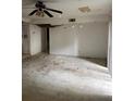 Living room needing repair featuring a ceiling fan and natural light from a window, open for renovation at 809 Camelot Dr # 809, College Park, GA 30349