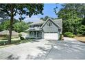 Two story home with a two car garage and a long driveway, surrounded by mature trees and greenery at 1655 Peachcrest Dr, Lawrenceville, GA 30043