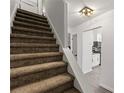 Stairway featuring carpeted stairs and decorative overhead lighting leading to the kitchen at 732 Jamestown Xing, Jonesboro, GA 30238