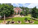 Well-manicured front yard featuring decorative plantings and a charming brick facade home at 805 Cog Hl, Mcdonough, GA 30253