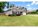 Inviting single-story home with lush green lawn, stone accents, and attached two-car garage at 132 Berkleigh Trails Dr, Hiram, GA 30141