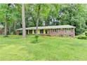 Charming brick home with a lush green lawn and mature trees providing shade and curb appeal at 1970 Fisher Ne Trl, Atlanta, GA 30345