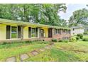 Inviting front porch with decorative iron posts, yellow siding, brick accents and stone walkway at 1970 Fisher Ne Trl, Atlanta, GA 30345