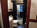 Cozy bathroom featuring black tile accents, toilet, shower with glass doors, and dark floral wallpaper at 2765 Rollingwood Se Ln, Atlanta, GA 30316