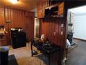 Rustic kitchen with wood paneled walls, dark appliances, and brick-surround fireplace at 2765 Rollingwood Se Ln, Atlanta, GA 30316