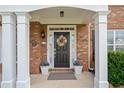Elegant front porch with decorative wreath, potted plants, and white columns at brick home entrance at 3850 Calomel Dr, Cumming, GA 30040