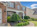 Close up of a charming two-story brick home showcasing a well-landscaped front yard and walkway at 3850 Calomel Dr, Cumming, GA 30040