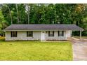 A quaint, single-story home with stone foundation, attached carport, and lush green lawn at 3645 Shrewsbury Ct, Snellville, GA 30039