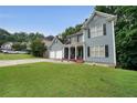 Stylish two-story home with lush green lawn, attached two-car garage and covered porch with seating at 4321 Clairesbrook Ln, Acworth, GA 30101